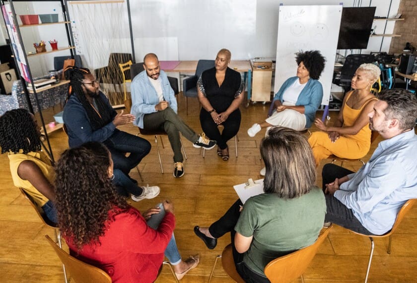 A diverse group engaged in a lively discussion in a modern office.